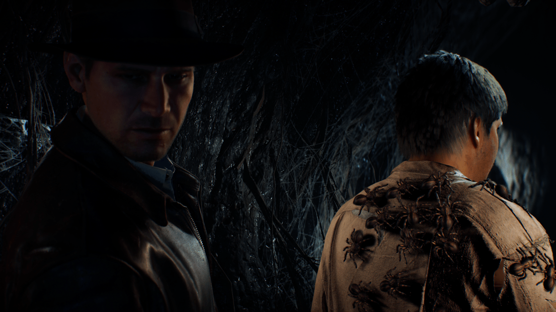 indy looking away from a man with a lot of spiders on his back.