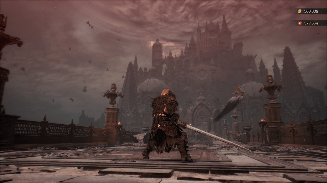 A warrior figure, seen from behind, stands on a stone bridge, framed by an imposing gothic-style castle in the distance. The sky is heavily overcast, giving the scene a somber, apocalyptic feel. The warrior is clad in dark, textured armor, and wields a large sword. The bridge shows signs of disrepair.