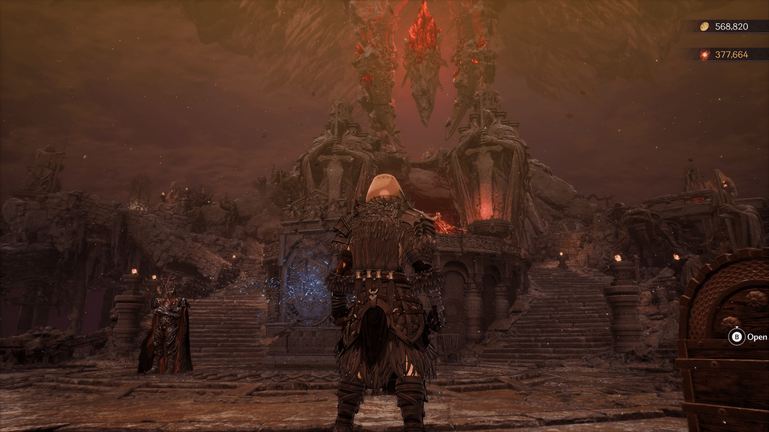A third-person perspective from a dark fantasy game. The player character, wearing detailed dark armor with fur trim, stands on a stone platform facing a large, ornate structure in a desaturated reddish environment. The structure is flanked by stone statues and topped with three large, floating red crystals. A second character in a red and black ornate robe stands to the left. The sky is a murky reddish-brown, and the scene evokes a sense of foreboding and high fantasy adventure.