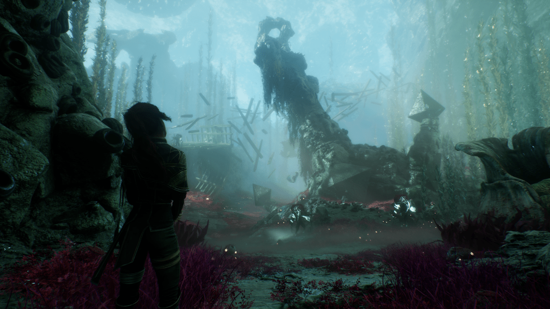 Wide shot. The silhouette of a woman at left, facing right third of frame. An underwater landscape filled with stone ruins and large coral formations stretches into the distance. The water is murky, lit with a diffuse, blue glow. There are floating pieces of debris and what appears to be the remnants of wooden structures. Red and purple plant life dots the foreground. The composition conveys a sense of depth and atmospheric perspective.