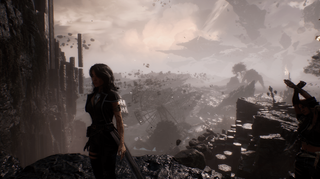 A woman with dark hair, dressed in dark, tailored clothing, stands on a rocky ledge in a desolate, surreal landscape. A ruined Ferris wheel is visible in the mid-ground. In the background, there are floating rocks, a distant mountain range, and a cloudy sky. Another figure with raised arms is on another rocky outcrop to the right.