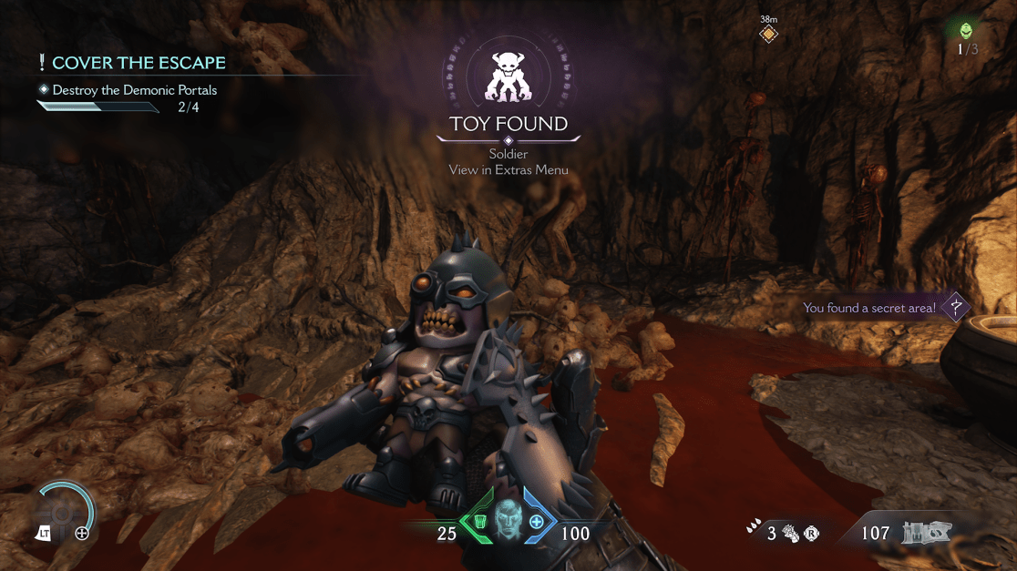 The image shows a first-person perspective from a video game. The player is inside a dark, rocky cave with a reddish stream flowing through it. The cave walls are textured with various shades of brown and grey. In the foreground, the player's hands are visible, holding a "Toy Soldier" collectible. Text on the screen indicates that the toy soldier has been found. In the upper left corner, the primary game objective is displayed: "Cover the Escape" with a sub-objective to "Destroy the Demonic Portals," showing progress as "2/4." The top center of the image shows the in-game notification "Toy Found" along with an icon of the toy. In the top right corner, there is a distance marker, and an indication that a secret area has been found. Additional skeletons and scenery elements line the walls of the cave.